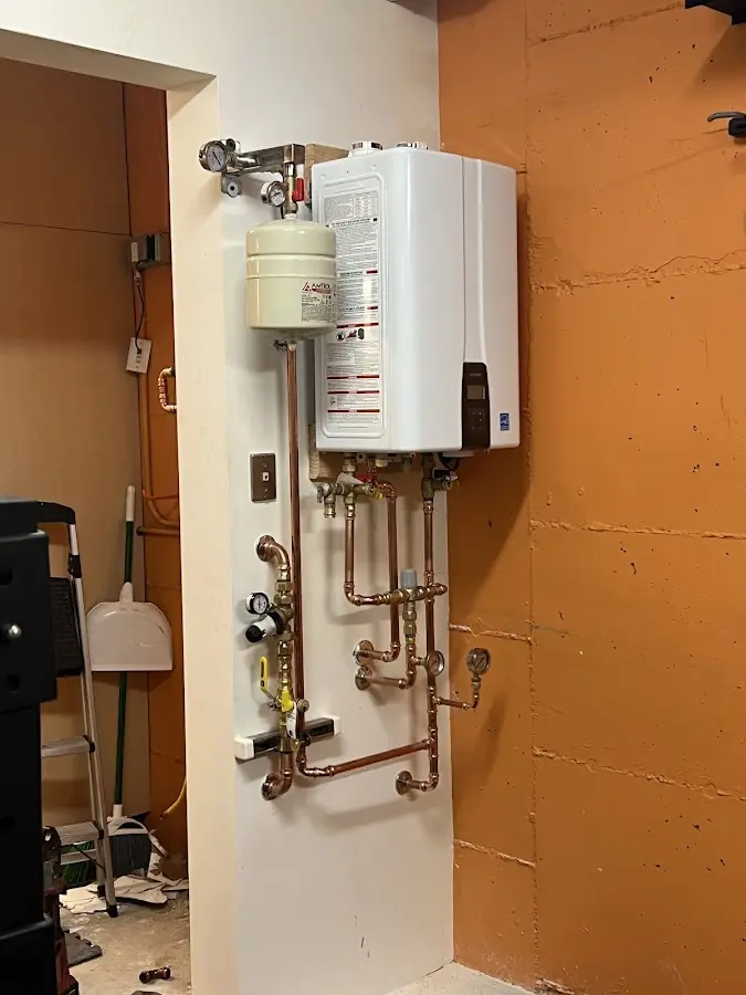 Plumbing technician inspecting water heater connections in Dover